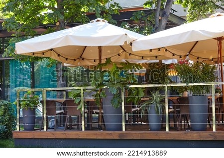 Restaurant terrace umbrella with light lamp bulbs. Modern exterior of summer cafe. Blurred image, selective focus