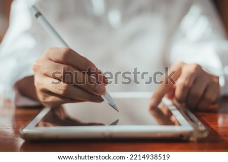 Close up of business hand signing contract on digital tablet, business person use electronic pen for sign agreement finance in office or workplace. communication technology. Royalty-Free Stock Photo #2214938519