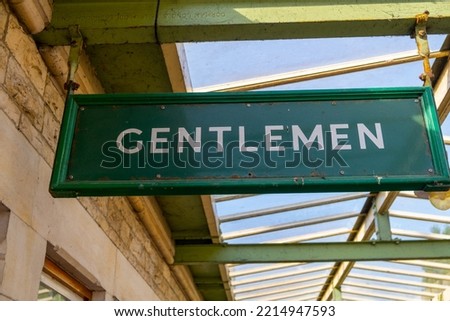 gentlemen toilets sign in green on train station 