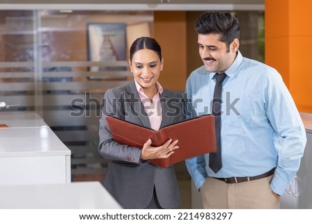  Businesswoman discussing over document with colleagues in office