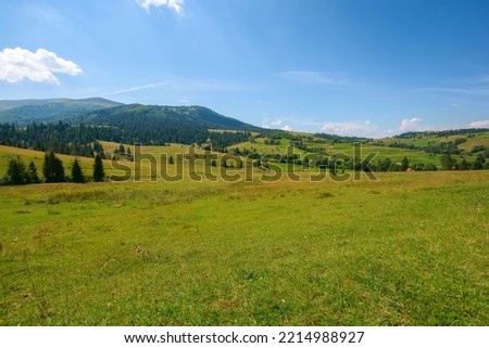 mountainous countryside landscape in summer. green rural scenery with grassy pastures and forested hills. wonderful sunny weather with blue sky Royalty-Free Stock Photo #2214988927