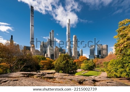Central Park in Fall with view of the skyscrapers of Billionaires Row in morning light. Midtown Manhattan, New York City