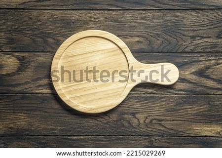 Wooden platter on oak table. Kitchen accessories for serve. Top view with copy space