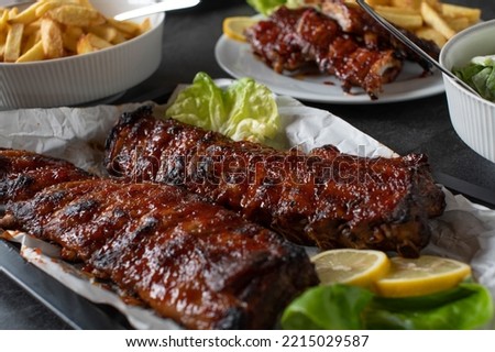 Barbecue pork meal with fresh grilled spareribs, homemade french fries and salad Royalty-Free Stock Photo #2215029587