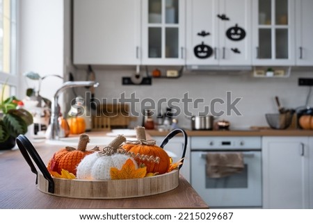 The interior of the Scandi-style white kitchen is decorated with pumpkins for Halloween. Autumn mood, home decor for the holiday