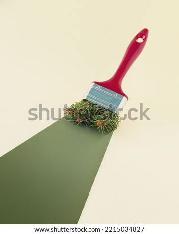2023. Abstract aesthetic decorative New Year concept. Paintbrush with Christmas tree twigs paints green trace. Pastel beige background with copy space. Creative Xmas greeting or gift card. Minimalism. Royalty-Free Stock Photo #2215034827
