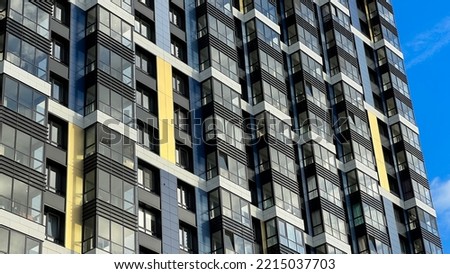 The facade of the building is purple,geometric patterns from windows and balconies, the colored wall of a modern multi-storey residential building, the abstract texture of the facade of the house.