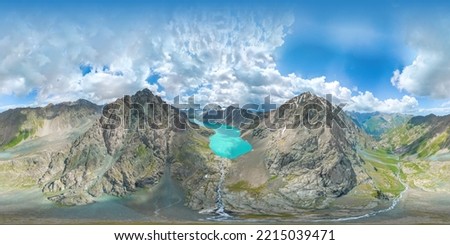 Fresh lake high in the mountains of Kyrgyzstan.On the panorama 180 there are two sharp mountains between them a high-altitude azure, clean, fresh, cold, fabulous pond lake. There are lacy clouds.