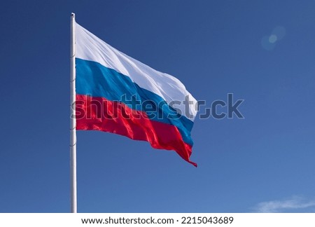 Russian flag on a background blue sky. Lens flare effect.