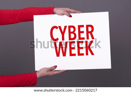 Female hands holding a cyber week poster. Studio shot.