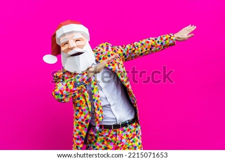 Happy man with funny low poly mask of Santa Claus on colored background - Creative conceptual idea for Christmas holiday, advertising, adult with low-poly origami paper mask doing funny poses