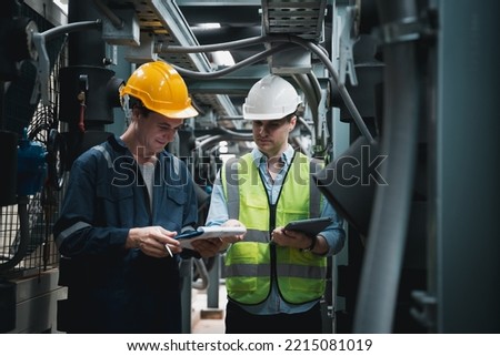 Engineer and team examining the air conditioning cooling system of a huge building or industrial site. Royalty-Free Stock Photo #2215081019