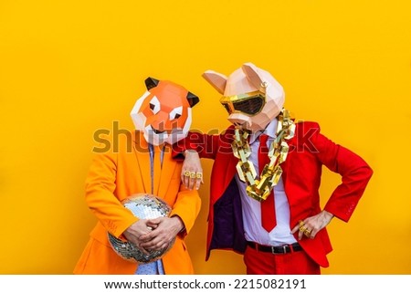 Cool men wearing 3d origami mask with stylish colored clothes - Creative concept for advertising, animal head mask doing funny things on colorful background