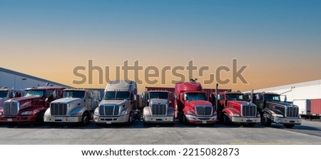 Lined up Semi trucks on a parking lot at logistics warehouse. Royalty-Free Stock Photo #2215082873