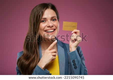 Happy woman holding credit card pointing finger. Isolated advertising portrait on pink back. 