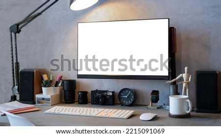 Creative workplace with computer, camera, stationery and coffee cup. Blank screen for your design.