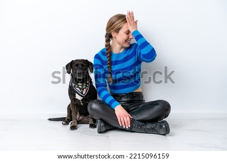 Young caucasian woman sitting on the floor with his puppy isolated on white background has realized something and intending the solution