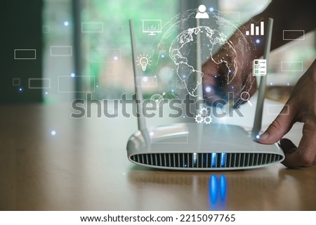 Selective focus at router. Internet router on working table with blurred man connect the cable at the background. Fast and high speed internet connection from fiber line with futuristic icon Royalty-Free Stock Photo #2215097765