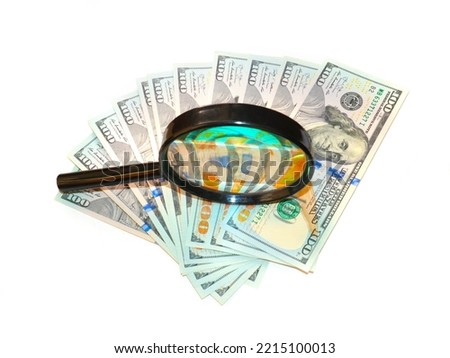 American paper bills dollars and a magnifying glass to check them