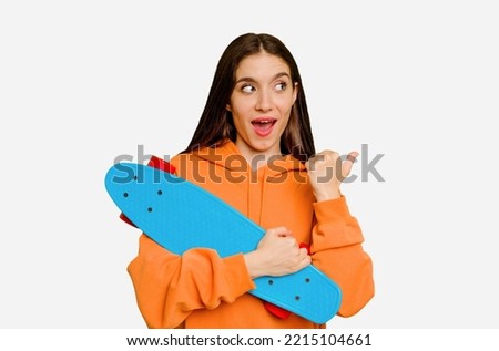 Young skater caucasian woman isolated points with thumb finger away, laughing and carefree.