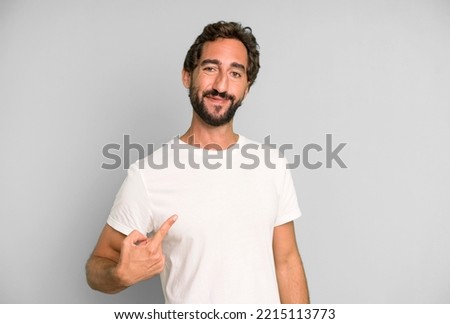 young crazy man looking proud, confident and happy, smiling and pointing to self or making number one sign