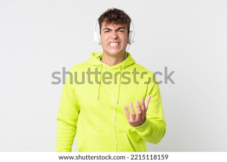 young handsome man looking angry, annoyed and frustrated and headphones