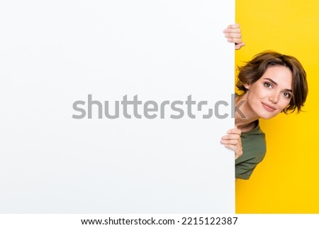 Photo of pretty cute sweet lady dressed stylish clothes hand hold empty space head look out big wall isolated on yellow color background