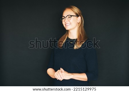 Studio portrait of beautiful confident woman posing on black background