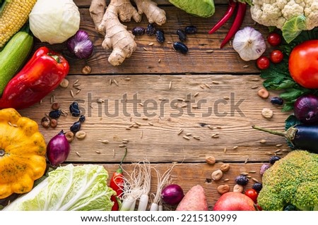Vegetables frame on wooden background, flat lay composition.