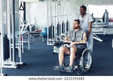 African doctor pushing patient with disability in wheelchair for sport exercises in health club