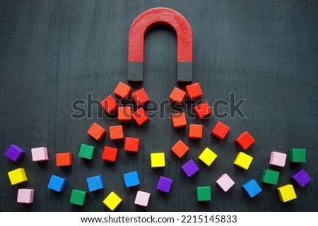 The magnet attracts colored cubes. Leads generation and acquisition concept. Royalty-Free Stock Photo #2215145833