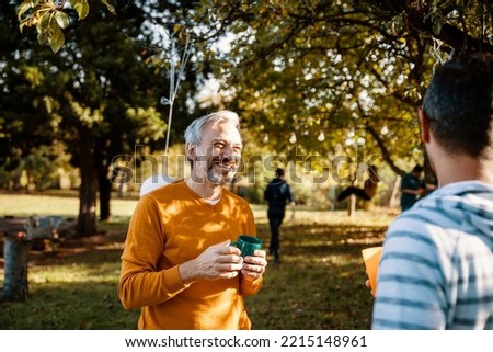 Mature Grey hair Man hangs out with his friend on the sunny day outdoors Royalty-Free Stock Photo #2215148961