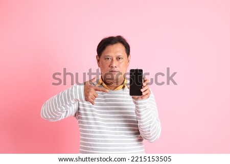 The 40s adult overweight Asian man standing on the pink background.