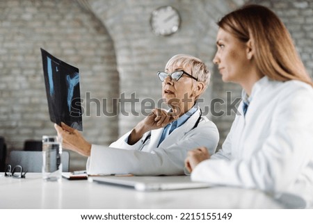 Two medical experts  examining an X-ray image in the office