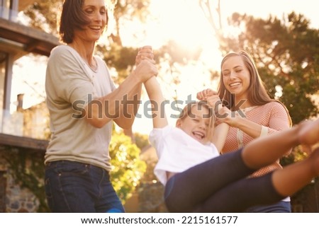Three generations having great fun. Shot of a little girl playing outside with her mother and grandmother.