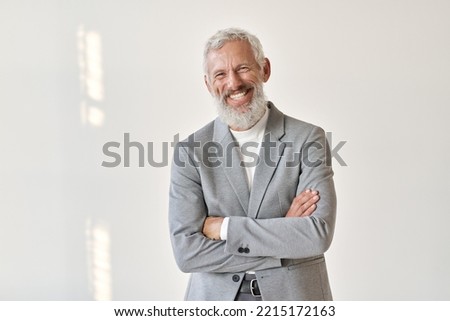 Happy laughing old bearded business man leader executive, smiling middle aged old senior confident professional businessman wearing suit standing arms crossed isolated on white wall, portrait.