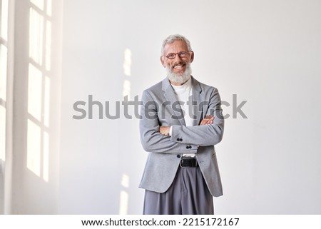 Happy mature older gray-haired business man leader, smiling middle aged old senior professional businessman teacher wearing suit and glasses standing arms crossed isolated on white wall. Royalty-Free Stock Photo #2215172167