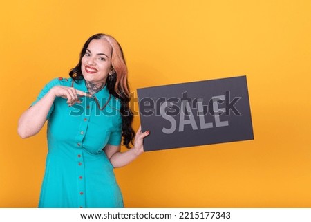 Beautiful woman pointing at a Sale sign