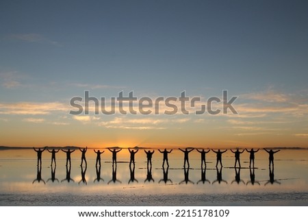 people silhouette in the Uyuni salt flat sunrise