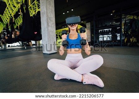 Woman wearing glasses of the virtual reality exercising with dumbbells