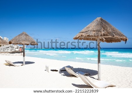 Sun umbrella ans sunbed on white sandy beach with turquoise ocean water. Caribbean sea travel destination. Bounty and pristine nature for vacation. Nobody Royalty-Free Stock Photo #2215222839