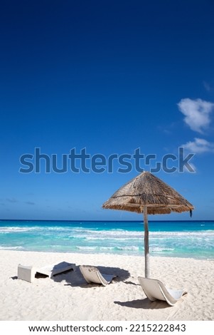 Sun umbrella ans sunbed on white sandy beach with turquoise ocean water. Caribbean sea travel destination. and pristine nature for vacation. Nobody Royalty-Free Stock Photo #2215222843