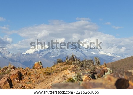 View of snow-capped mountains, mountains, meadow, some vegetation, rocks, sky and clouds in the afternoon, located high in the Peruvian highlands in Chicarhuapunta, province of Huaylas, Ancash - Peru Royalty-Free Stock Photo #2215260065