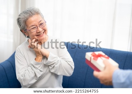 ็Happy senior woman feeling good when someone giving a gift box for herself. Happy Elderly Asian.