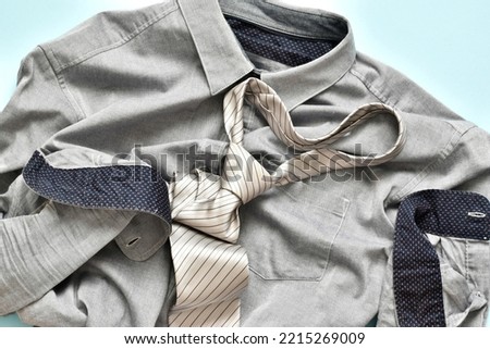 Gray male shirt with necktie on light blue background. Flat lay. Top view, banner with copy space. Template greeting card for mens day. 