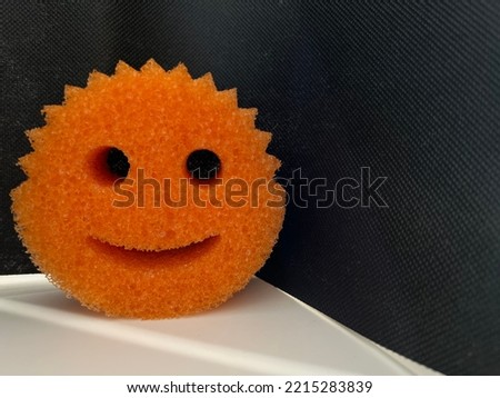 Bright orange smiley face Halloween image on a black and white background