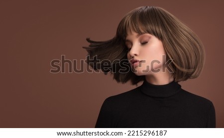 Portrait of a beautiful brown-haired woman with a short haircut on a brown background Royalty-Free Stock Photo #2215296187