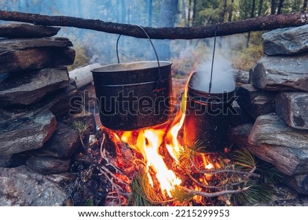 Camping pot on fire. Outdoor steaming food. Wildlife lifestyle cooking delicious meal, Copyspace stock photo