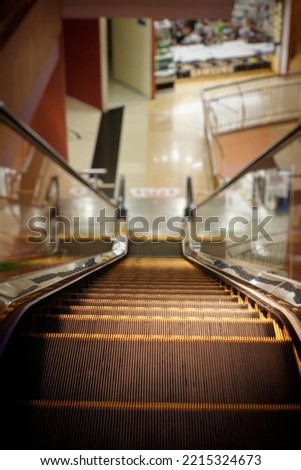 highlighted excalator with blurred lower level floor inside department store