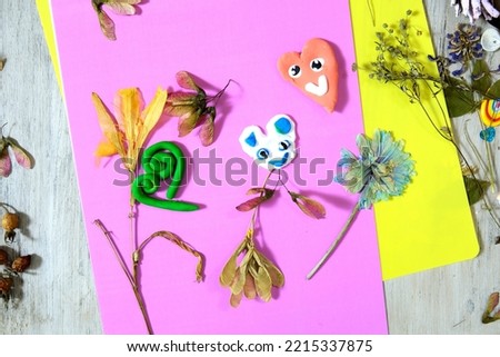 Autumn crafts. Child making crafts from natural dry plants, flowers, grass and leaves use paper and plasticine. Back to school. Ideas for children's art